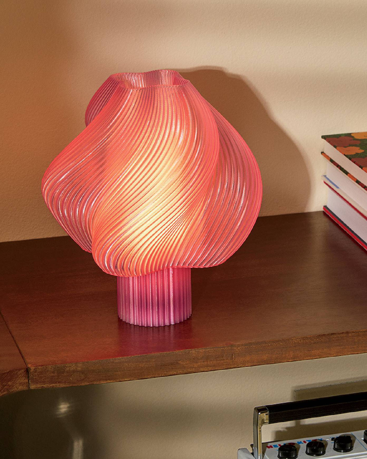 A pink lamp on a table.