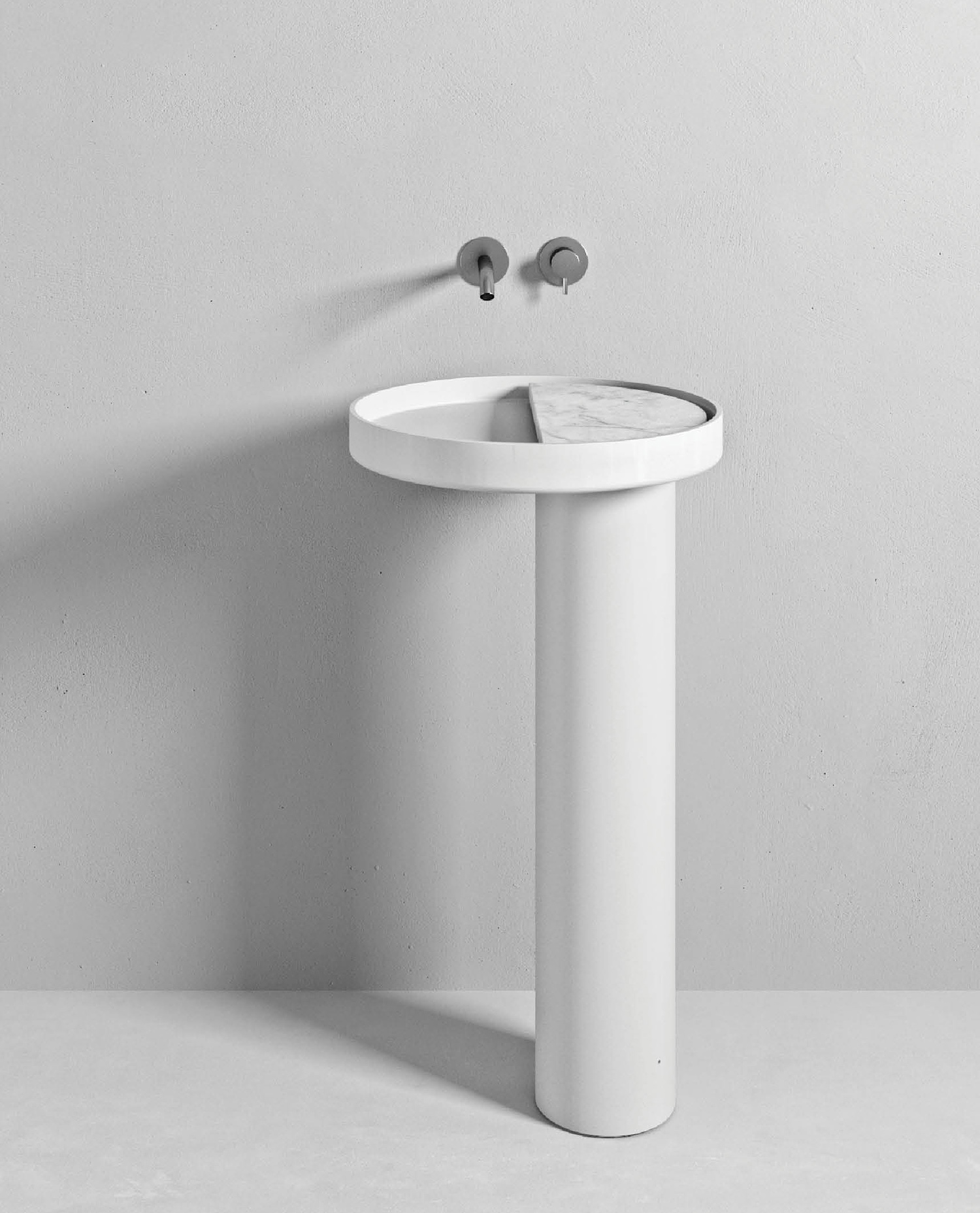 a white pedestal with a sink and a faucet