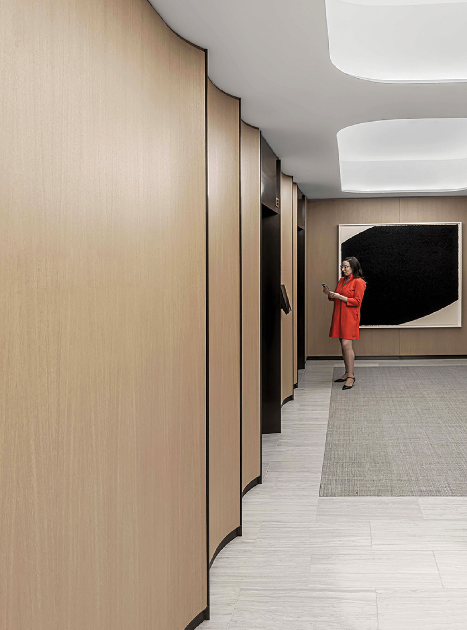 A woman in a red dress is standing in a hallway.