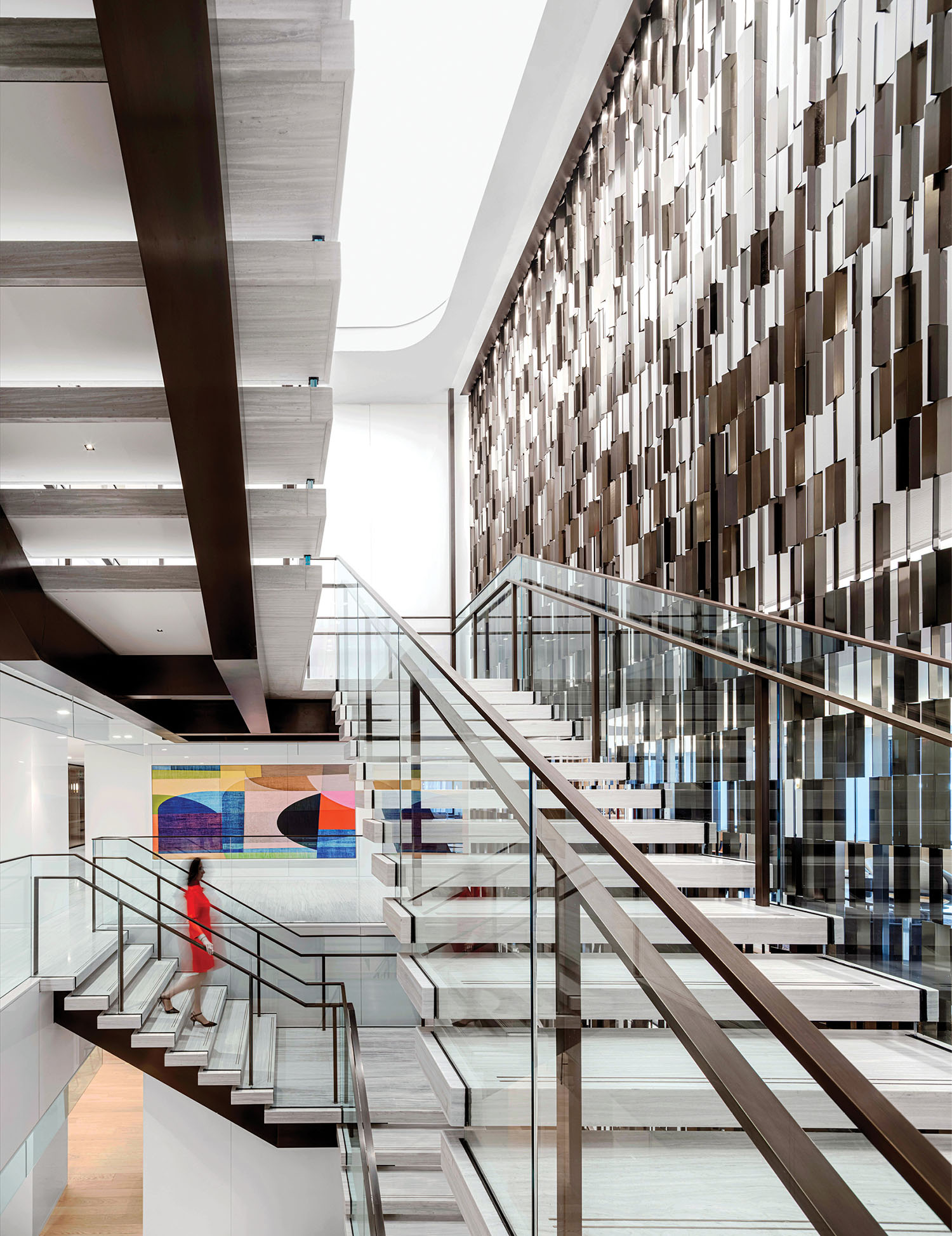 A staircase with a glass railing and a metal handrail.