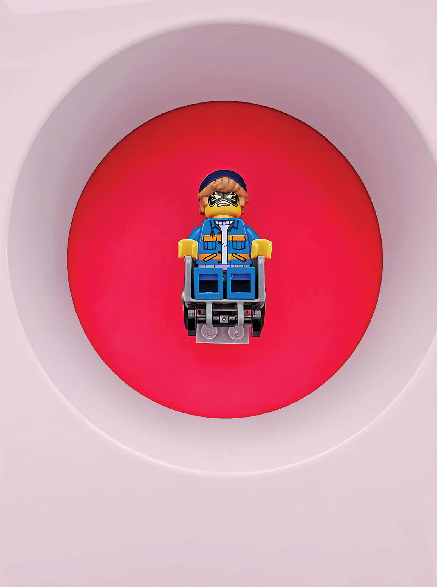 A lego man sitting on top of a toilet.