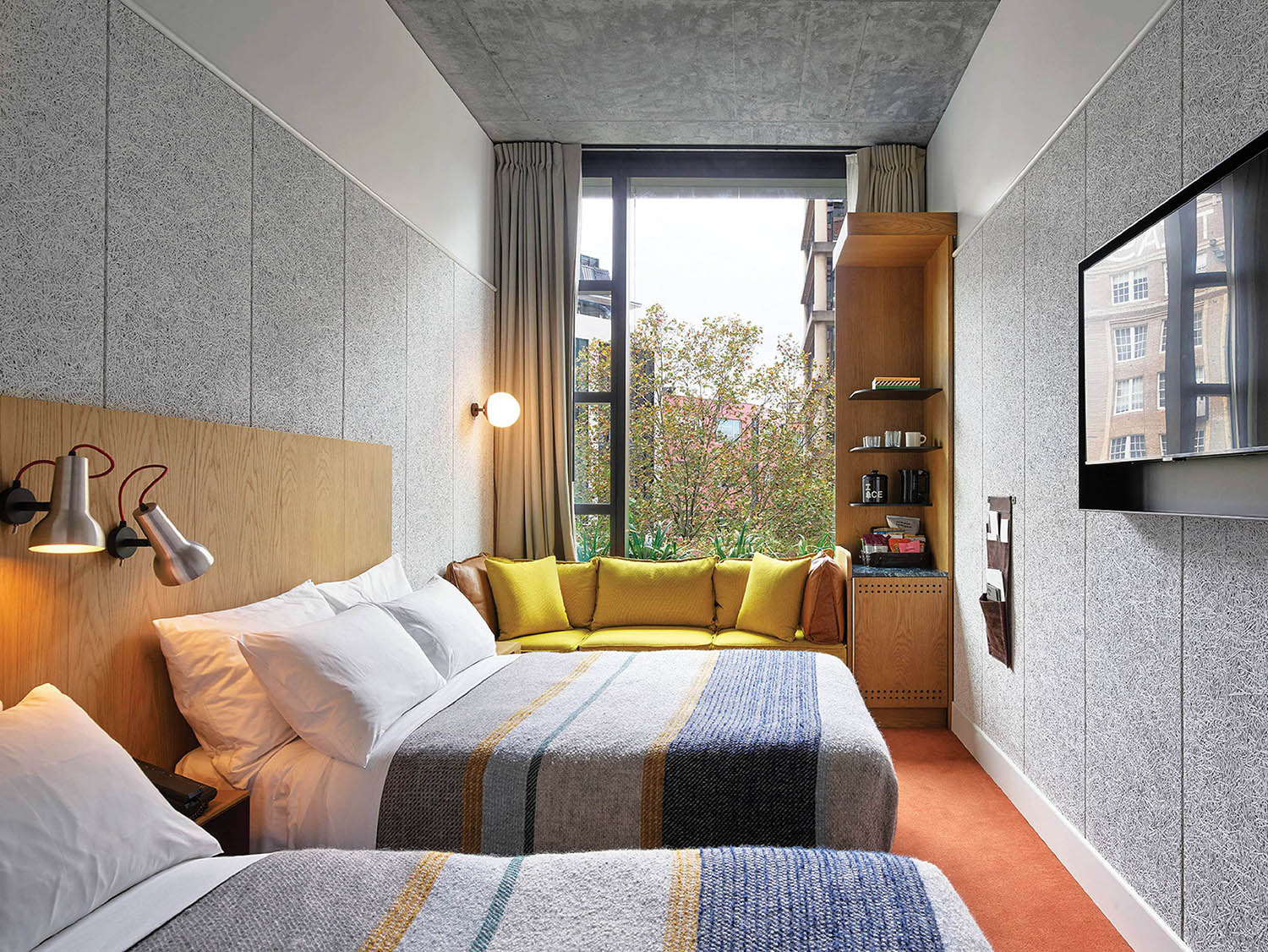 A bedroom with two beds and a television.