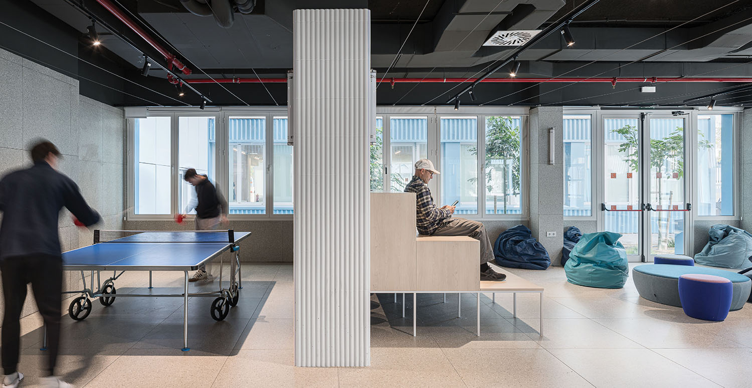 a man is playing ping pong in a large office