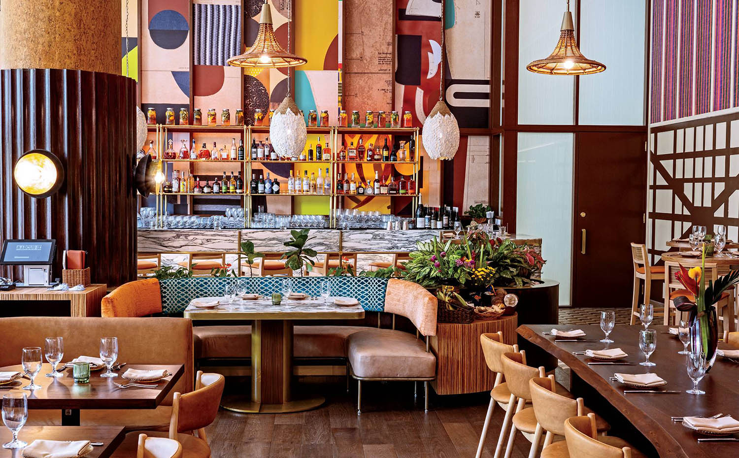 A restaurant with a large bar and a long table.