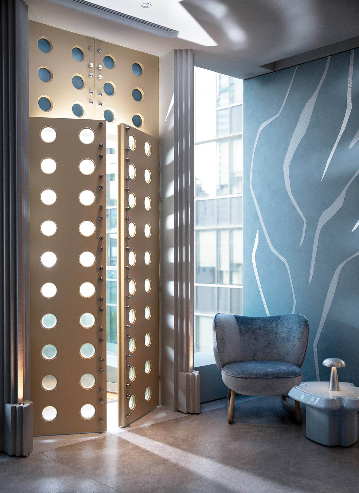 A room with a chair and a wall with circles.