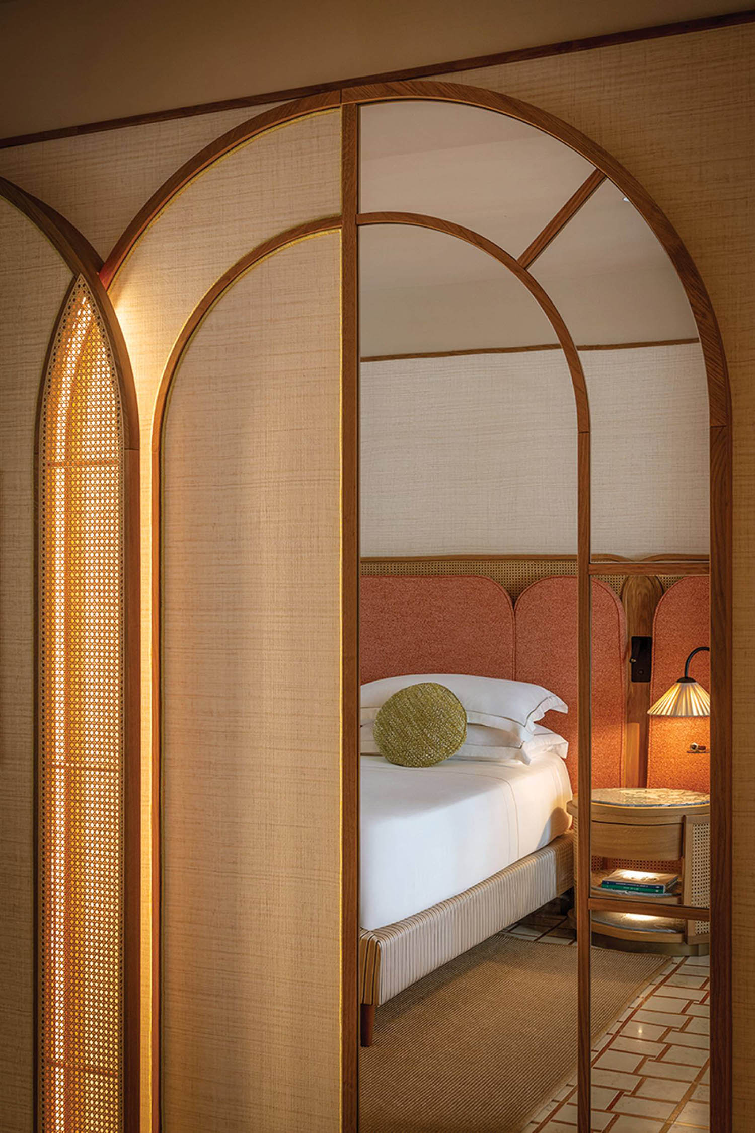 A bed sitting in a room with a mirror.