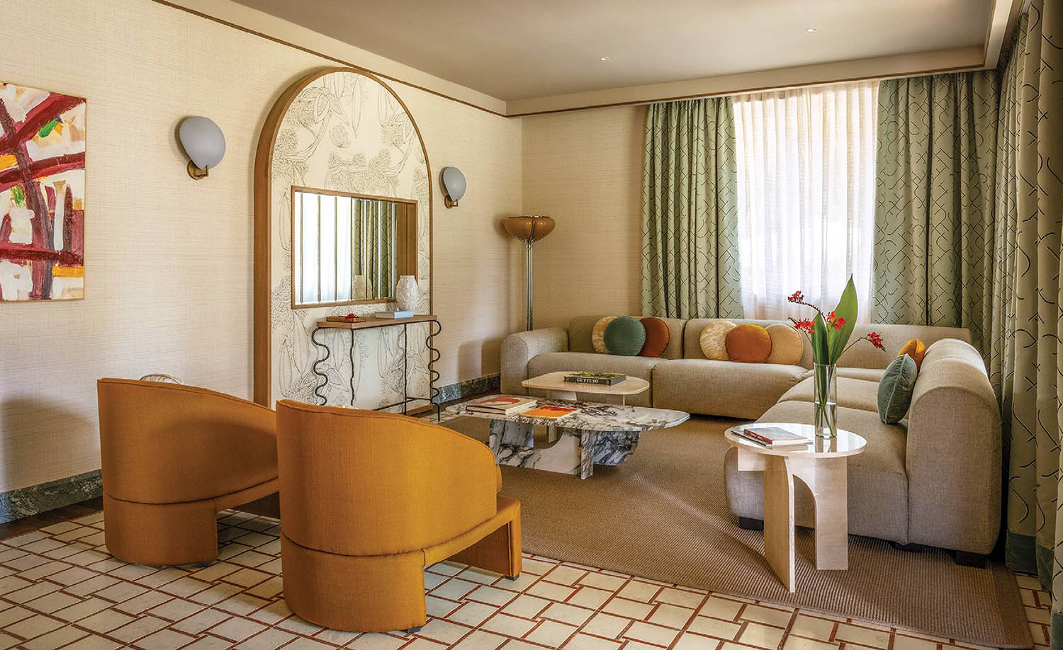 A living room with a couch, chair, mirror and a table.