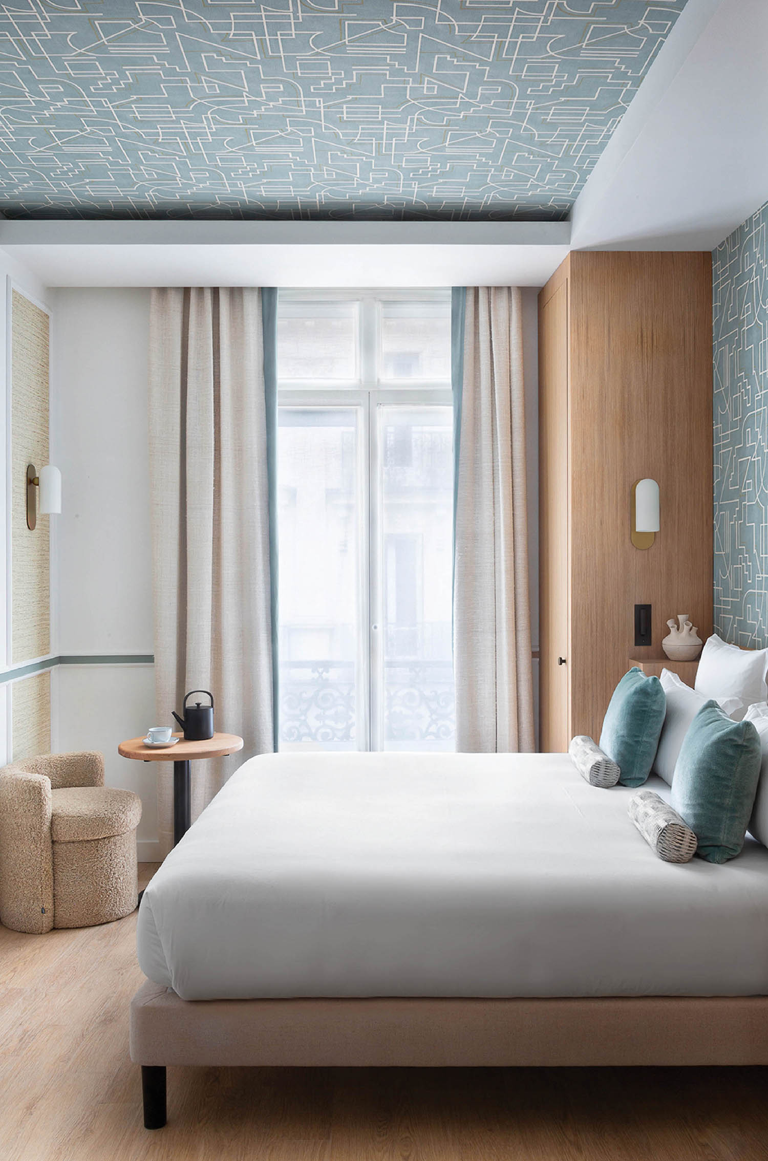 A bedroom with a bed and a wallpapered ceiling.