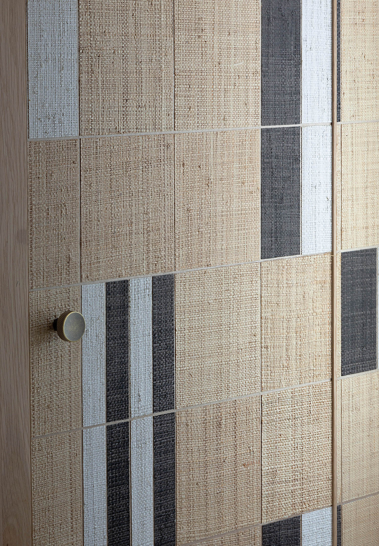 A bathroom with a toilet and a tiled wall.