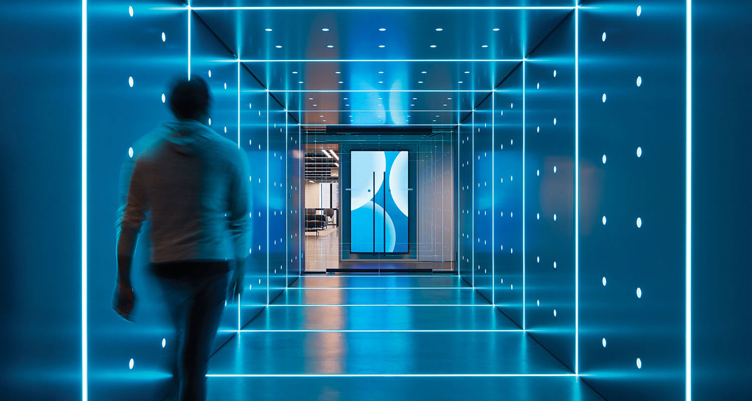 man walking through a blue vortexlike office hallway