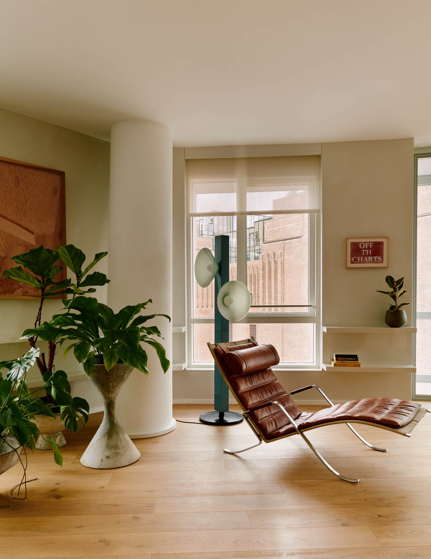 corner of room with long brown chair and standing planters
