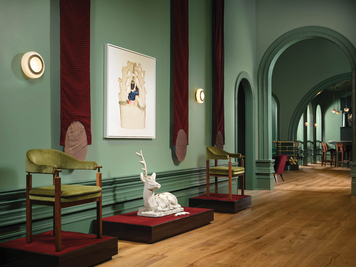 display of artwork in the hallway with green walls